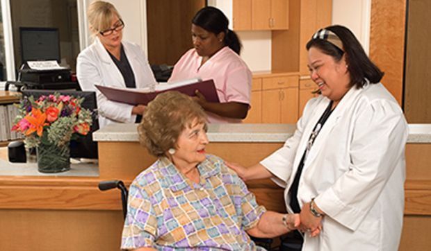 A nurse speaking with a woman in a wheelchair