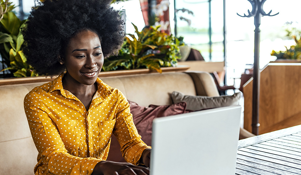 Woman on a bench working on a computer