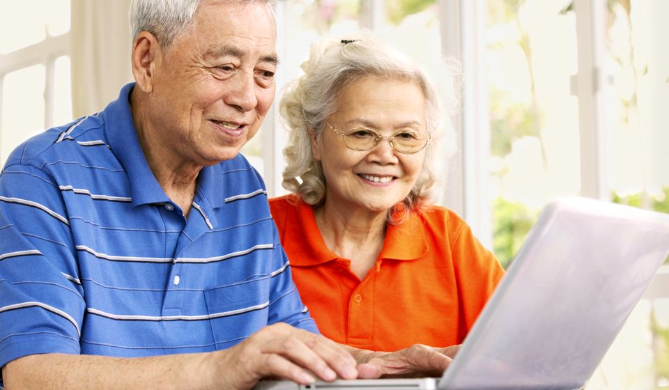 A couple sitting at a laptop