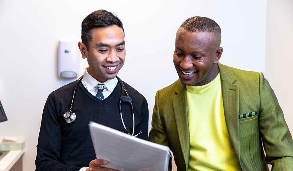 A doctor showing a medical chart to a patient in a doctor's office.