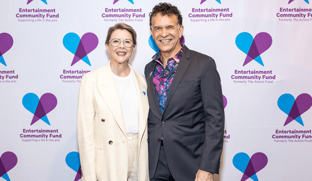 Annette Bening and Brian Stokes Mitchell standing in front of a backdrop with the Entertainment Community Fund Logo