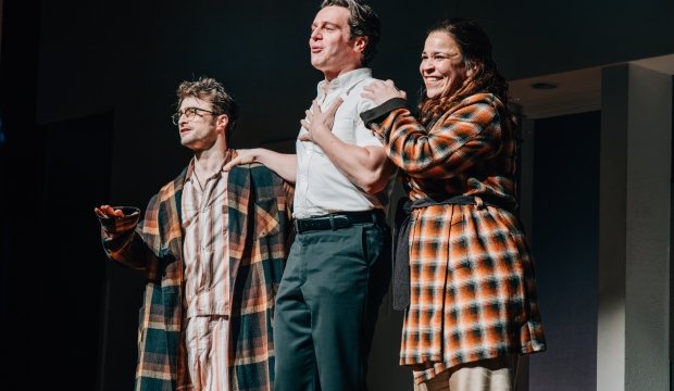 Two men and one woman on stage singing