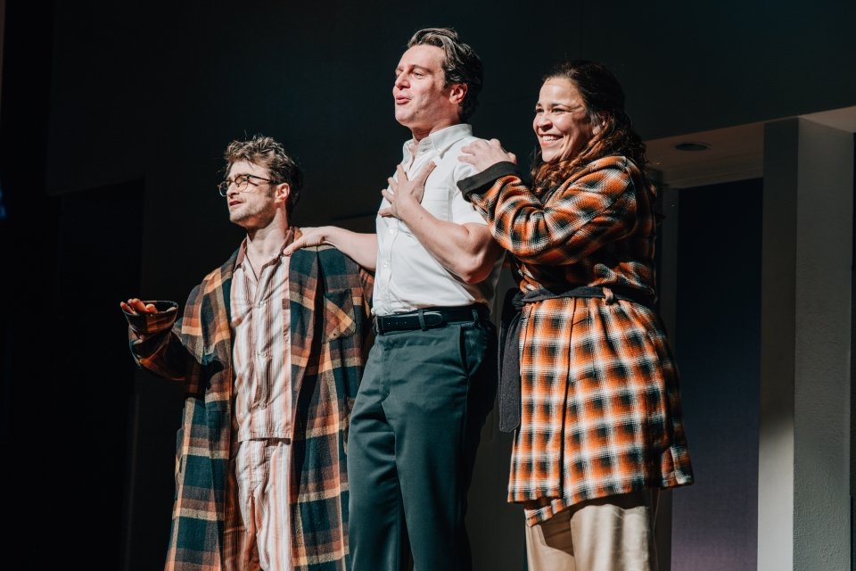 Two men and one woman on stage singing