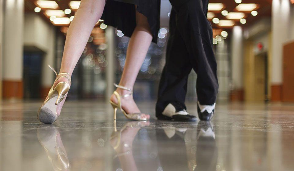 Focus on two people's shoes. The woman wears high heels, the man in fancy dress shoes.